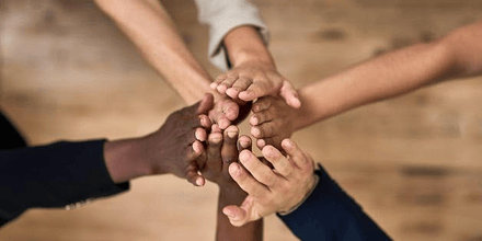 En grupp människor som håller ihop sina händer.