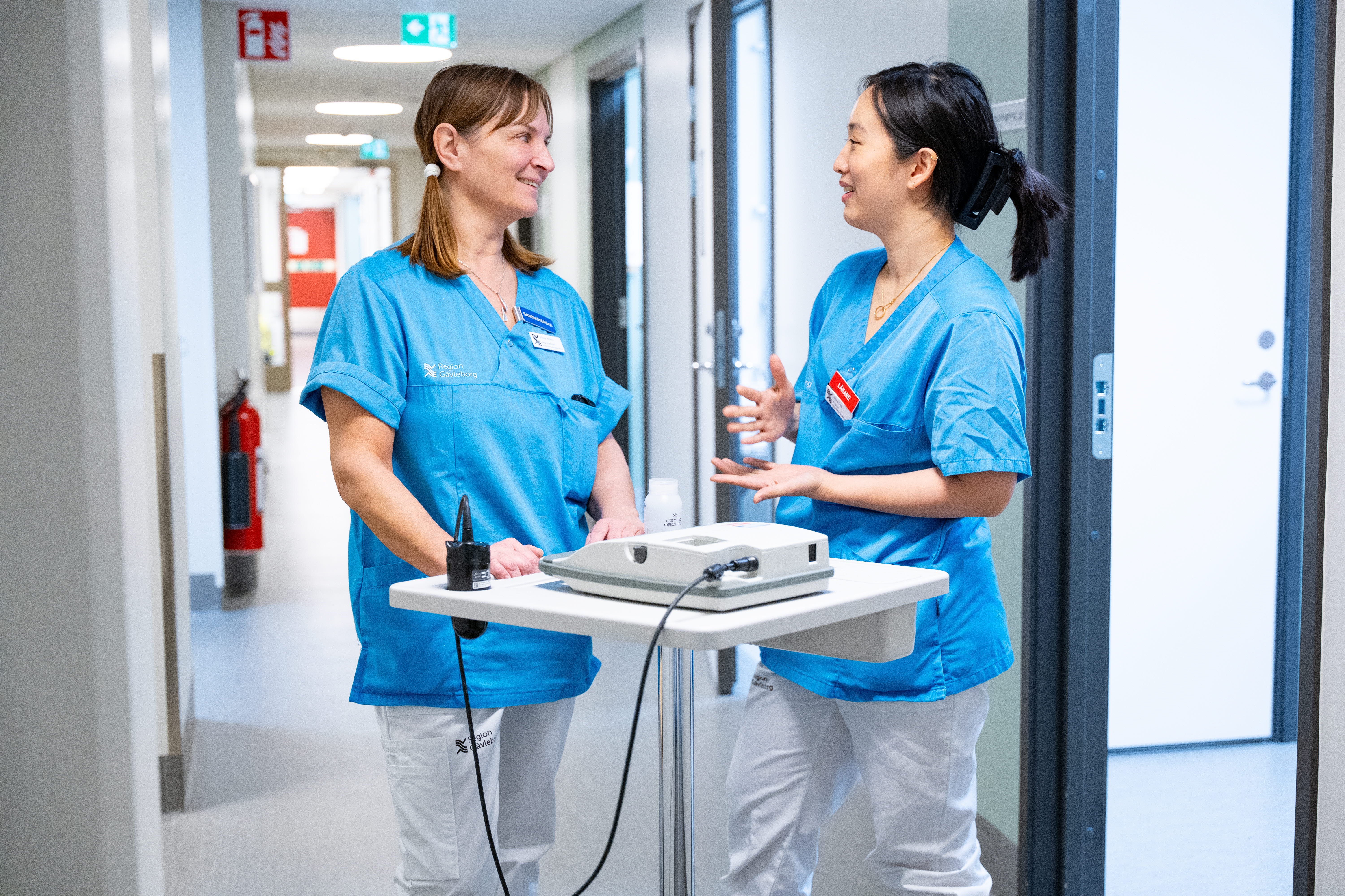 Två vårdmedarbetare diskuterar i korridor 