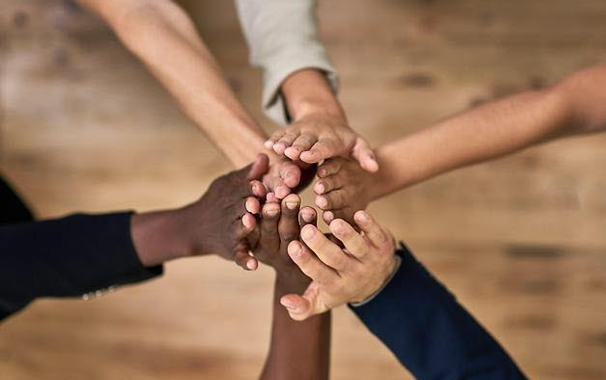 En grupp människor som håller ihop sina händer.